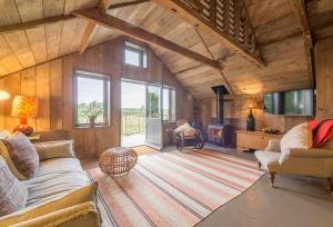 Snow Hall Barn في Peasenhall: غرفة معيشة مع أريكة ومدفأة