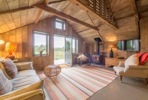 a living room with a couch and a fireplace at Snow Hall Barn in Peasenhall