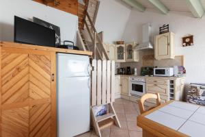 a kitchen with a white refrigerator and a table at L'Alpiniste in Ancelle