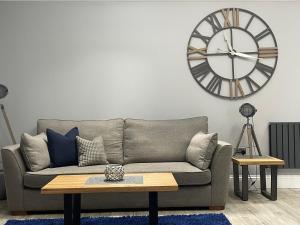 a living room with a couch and a large clock on the wall at The Store, Luxury modern conversion with open plan living - Sleeps 4 in Wick