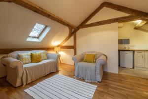 ein Wohnzimmer mit 2 Sofas und einem Fenster in der Unterkunft Woodland Retreat Lodge in Brundish