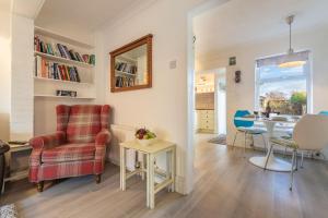 a living room with a chair and a table at Hideaway Cottage in Leiston