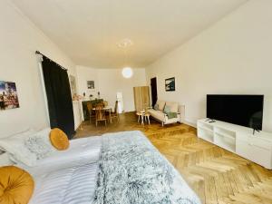 a bedroom with a large bed and a living room at aday - Beautiful Suite in Frederikshavn
