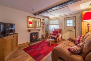 a living room with a couch and a fireplace at Flint Cottage in Wenhaston