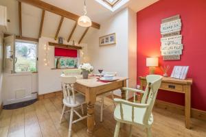 a dining room with a wooden table and chairs at Flint Cottage in Wenhaston