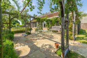 an outdoor patio with a table and chairs at Court Barn in Stoke-by-Nayland