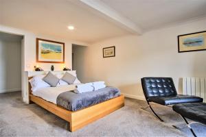 een slaapkamer met een bed en een zwarte stoel bij Imperial Apartment in Oban