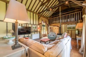 a living room with a couch and a lamp at Rose Barn in Stoke by Nayland