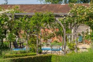 a garden with a swimming pool and a house at Rose Barn in Stoke by Nayland