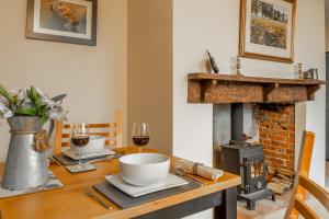 a dining room with a table with a fireplace at The School Room in Stowmarket