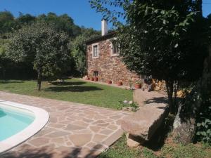 an external view of a stone house with a swimming pool at Casa do Adro-Passadiços do Paiva Arouca in Arouca