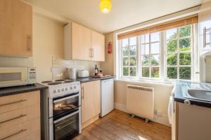 a kitchen with a stove top oven next to a window at Honeypot Cottage in Ipswich