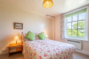 a bedroom with a bed and a window at Honeypot Cottage in Ipswich