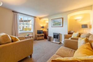 sala de estar con 2 sofás y TV en Bovis Cottage en Southwold