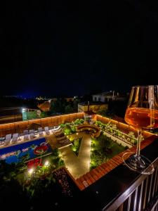 una copa de vino en la parte superior de un balcón con piscina en Boutique Hotel Kviria en Tʼelavi