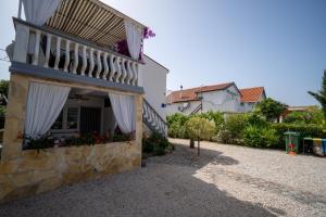 a house with a balcony with flowers on it at Apartman Mira in Vir