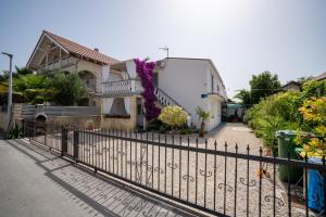 a fence in front of a house at Apartman Mira in Vir +19 photos