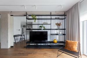 a living room with a tv and a black shelf at Odra Apartments in Wrocław