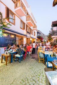 a group of people sitting at tables outside a restaurant at Kalkan Han Hotel in Kalkan