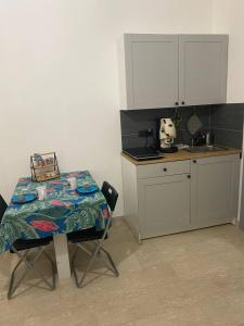 uma cozinha com uma mesa e uma mesa e um balcão em Hera Bnb em Metaponto