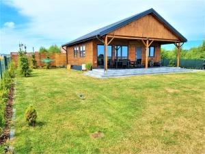 a house with a large yard in front of it at Gąski Baltic Lark Dom 100m2 3 sypialnie 2 łazienki Sauna Prywatny teren in Gąski