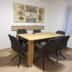 a wooden table with chairs around it in a room at Apartmaji Pri Medvedu in Bohinj