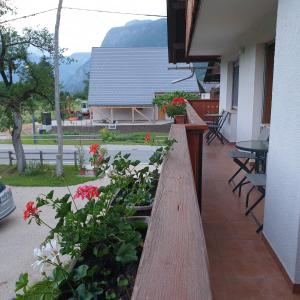 a wooden fence with flowers on a patio at Apartmaji Pri Medvedu in Bohinj +3 photos