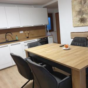 a kitchen with a wooden table and black chairs at Apartmaji Pri Medvedu in Bohinj