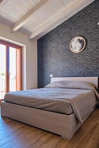 - une chambre avec un lit et un mur en briques dans l'établissement Eclissi, à Aielli
