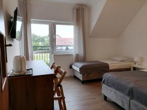 a small room with two beds and a window at Alma in Nickelswalde
