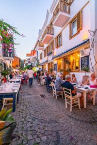 a group of people sitting at tables on a street at Kalkan Han Hotel in Kalkan