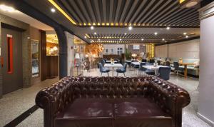 a leather couch in a room with tables and chairs at Harbiye Residence in Istanbul