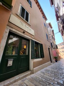 a building with a green door on a street at Tre Porte Rovinj in Rovinj