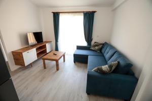 sala de estar con sofá azul y TV en Linaden Apart, en Kumluca