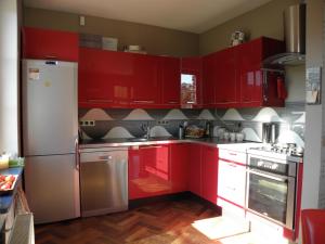 a red kitchen with white appliances and red cabinets at Skalny Dom in Stronie Śląskie