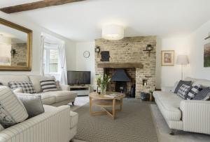 sala de estar con muebles blancos y chimenea en Upper End House, en Shipton under Wychwood