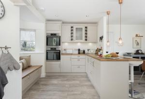 a kitchen with white cabinets and a counter top at Upper End House in Shipton under Wychwood