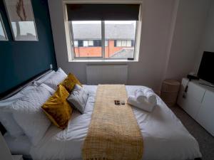a bedroom with a large white bed with a window at Pass the Keys Stunning 1 bedroom Penthouse in Nottm City Centre in Nottingham