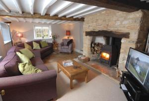 an overhead view of a living room with a stone fireplace at Gardeners Cottage in Shipton under Wychwood