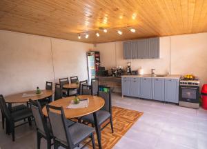 a room with tables and chairs and a kitchen at Casa AdiMan in Vama Veche