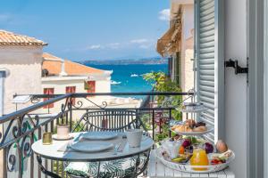 un balcone con tavolo e cibo sopra di Arolithos a Spetses