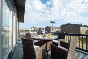 a patio with a table and chairs on a balcony at Hunky-Dory - Aldeburgh Coastal Cottages in Sizewell