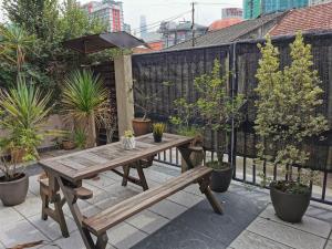 a wooden table and bench on a patio with plants at Cheras-Miharja Homestay @Sunway Velocity in Kuala Lumpur