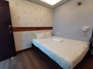 a bedroom with a large bed with white sheets at Cheras-Miharja Homestay @Sunway Velocity in Kuala Lumpur