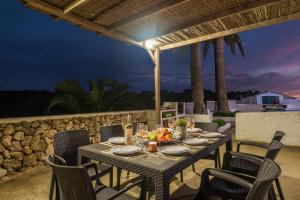 una mesa de comedor en el patio de una villa por la noche en Villa Mas Alta by Villa Plus en Ferreries