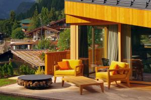 a patio with chairs and a table and a fire pit at Chalet La Ciaseta in Pozza di Fassa