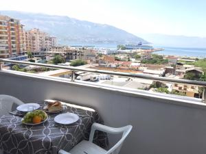 a table with a plate of fruit on a balcony at Despacito Port Side in Vlorë