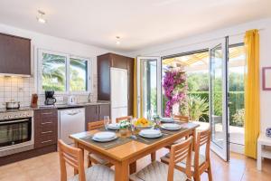 kuchnia i jadalnia ze stołem i krzesłami w obiekcie Villa Beatrice by Villa Plus w mieście Binibeca