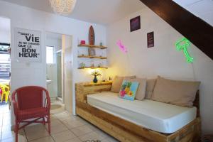 um quarto com uma cama e uma cadeira em Kaz Lotis - à 50m de la plage Roches Noires em Saint-Gilles-les-Bains