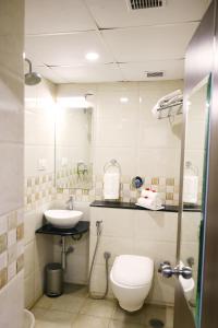 a bathroom with a toilet and a sink at Blue Ocean Residency in Bangalore